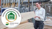 Frau inspiziert Bauplatten, darüber QNG-ready-Siegel